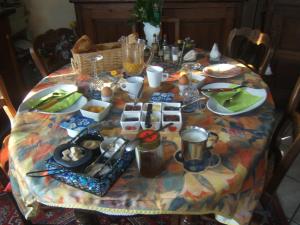 una mesa con un mantel con comida. en Relais du Cap romain en Saint-Aubin-sur-Mer