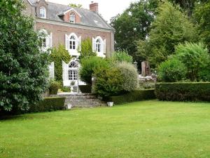 聖茹昂代蓋雷特的住宿－Chambres du Manoir de Blanche Roche，前面有草坪的大砖房子