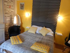 ein Schlafzimmer mit einem Bett mit zwei Kissen darauf in der Unterkunft Les Coquillettes in Honfleur