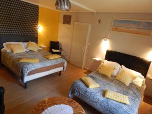 um quarto de hotel com duas camas e uma mesa em Les Coquillettes em Honfleur