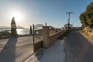 a stone fence with a gate on a road at Hectoras Villa in Plaka BY APOKORONAS-VILLAS in Plaka