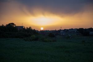 una puesta de sol sobre un campo con la puesta de sol en el fondo en Le Tre Giare, en Módica