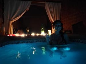 a woman holding a candle in a swimming pool at night at El Faro in Caldera