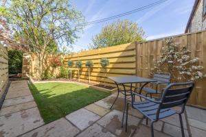 a backyard with a table and chairs and a fence at No33 THORNHAM BOUTIQUE COTTAGE 2 in Thornham +4 photos