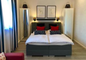 ガイゼンハイムにあるDAS Apartment am Weinbergのベッドルーム1室(赤と黒の枕が付くベッド1台付)