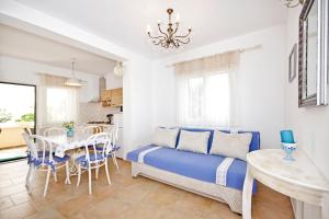 1 dormitorio con 1 cama azul, mesa y sillas en Apartmani Gordana, en Zaton