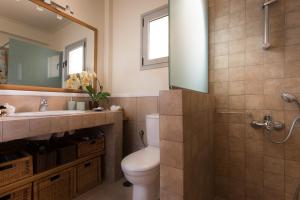 a bathroom with a toilet and a sink and a mirror at Comfortable house with amazing view in Anavyssos +24 photos