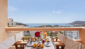 een tafel met ontbijtproducten op het balkon bij Comfortable house with amazing view in Anavissos