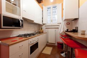 a kitchen with white cabinets and a stove top oven at Bed & Breakfast Parmacentro in Parma