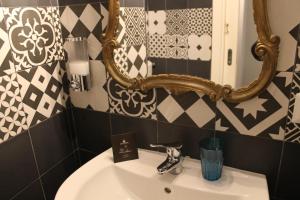 La salle de bains est pourvue d'un lavabo et d'un miroir. dans l'établissement Relais Arco Della Pace, à Rome