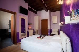 a bedroom with a white bed and purple walls at Bed & Breakfast Parmacentro in Parma