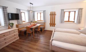 ein Wohnzimmer mit einem Esstisch und ein Schlafzimmer in der Unterkunft Schifterhof Ruhpolding in Ruhpolding