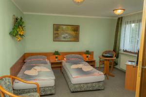 a hospital room with two beds and a table at Pension zum Schwanenteich in Neuhaldensleben