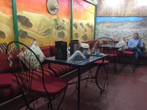 a woman sitting at a table in a restaurant at Riad Fes Touria Palace in Fez
