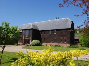 een grote zwarte schuur met een grijs dak bij North Downs Barn in Rochester