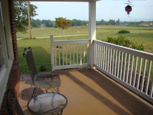 a porch with two chairs and a view of a field at The Chapman House in Lineville