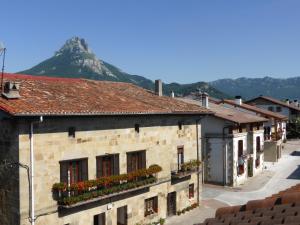 a street in a town with a mountain in the background at Casa Rural Reparaz in Arbizu