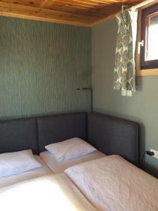 Una cama o camas en una habitación de Pfahlbau in Weiden am See