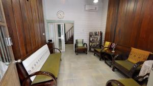 a waiting room with chairs and a clock on the wall at Home & Hashery Boutique House in Bangkok