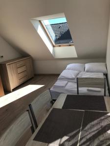 a attic room with two beds and a skylight at Baltic Vip Apartamenty Letnie w Rewalu in Rewal