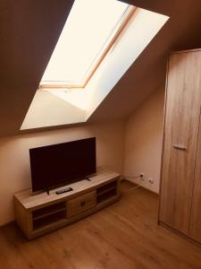 a living room with a flat screen tv and a skylight at Baltic Vip Apartamenty Letnie w Rewalu in Rewal