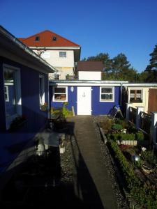 a blue house with a garden in front of it at Haus der 16 Seen in Krakow am See