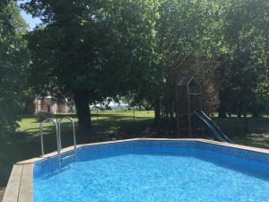 una piscina con tobogán y un parque infantil en La Grande Maison de Pont Lung, en Ygrande