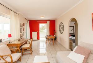 ハニア・タウンにあるThalassa Seaview Apartmentの赤い壁のリビングルーム(テーブル、椅子付)