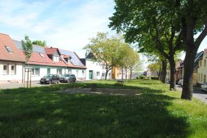 ein Park in einem Wohnviertel mit parkenden Autos in der Unterkunft FeWo Meikoe in Lutherstadt Eisleben