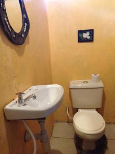 a bathroom with a sink and a toilet and a mirror at Maasai Simba Camp in Amboseli