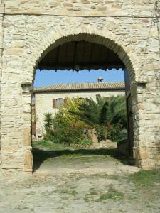 un arco en una pared de piedra con un edificio en Sa Domu de sa Contissa, en Sèlegas