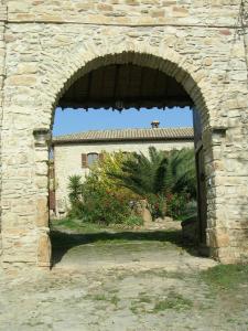 um arco numa parede de pedra com um edifício em Sa Domu de sa Contissa em Sèlegas