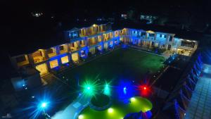 a building with blue and green lights at night at La Bellevue (Club & Resort) in Rāmnagar +19 photos