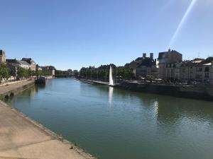 a river with a fountain in the middle of a city at Sympathique logement en centre ville in Verdun