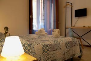 a bedroom with a bed with a lamp and a window at Area 12 BB in Trapani