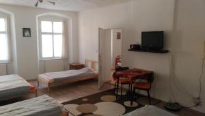 海布Skromný apartmán v centru Chebu的有两张床、一张桌子和一台电视的房间