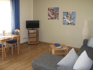 a living room with a couch and a tv at Ferienwohnung Schneemann in Valwig