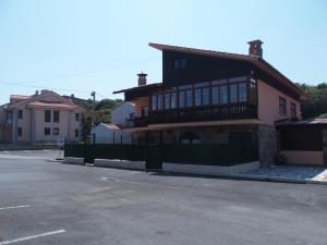 a house with a fence in front of a street at Casa Grande de Borizu Playa in Celorio