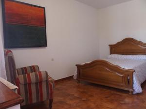 a bedroom with a bed and a chair at Casa Grande de Borizu Playa in Celorio