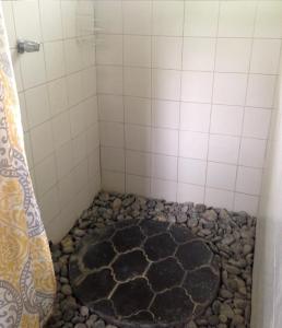 doccia con pavimento in pietra e tenda da doccia di Cabinas Sol y Mar a Zancudo