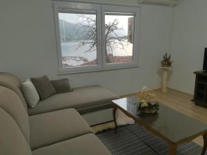 a living room with a couch and a table and two windows at Vila Mare in Ohrid