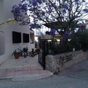 a house with a black gate and a tree at Five Fingers Holiday Bungalows in Kyrenia