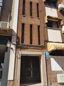 a large brick building with a large door at Hostal Puerta Bonita Vista Alegre, edificio sin ascensor in Madrid