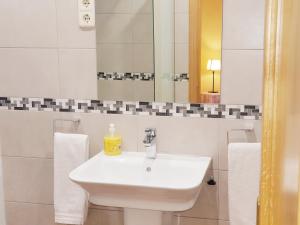 a white bathroom with a sink and a mirror at Hostal Puerta Bonita Vista Alegre, edificio sin ascensor in Madrid