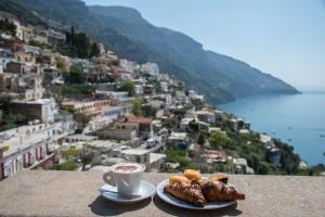 two plates of pastries and a cup of coffee on a ledge at Hotel Posa Posa in Positano