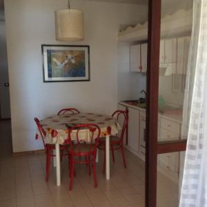 kuchnia i jadalnia ze stołem i krzesłami w obiekcie Appartamento in residence Laghi di Sibari w mieście Sibari