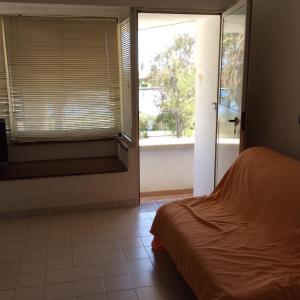 a bedroom with a bed and a sliding glass door at Appartamento in residence Laghi di Sibari in Sibari