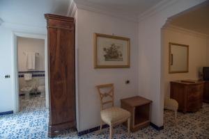 a room with a bathroom with a chair and a sink at Hotel Posa Posa in Positano