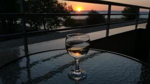 シオーフォクにあるClub 218 Wellness Stúdióの夕日を眺めながらグラステーブルに座るワイン