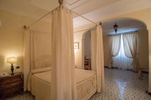 a bedroom with a canopy bed with curtains at Hotel Posa Posa in Positano